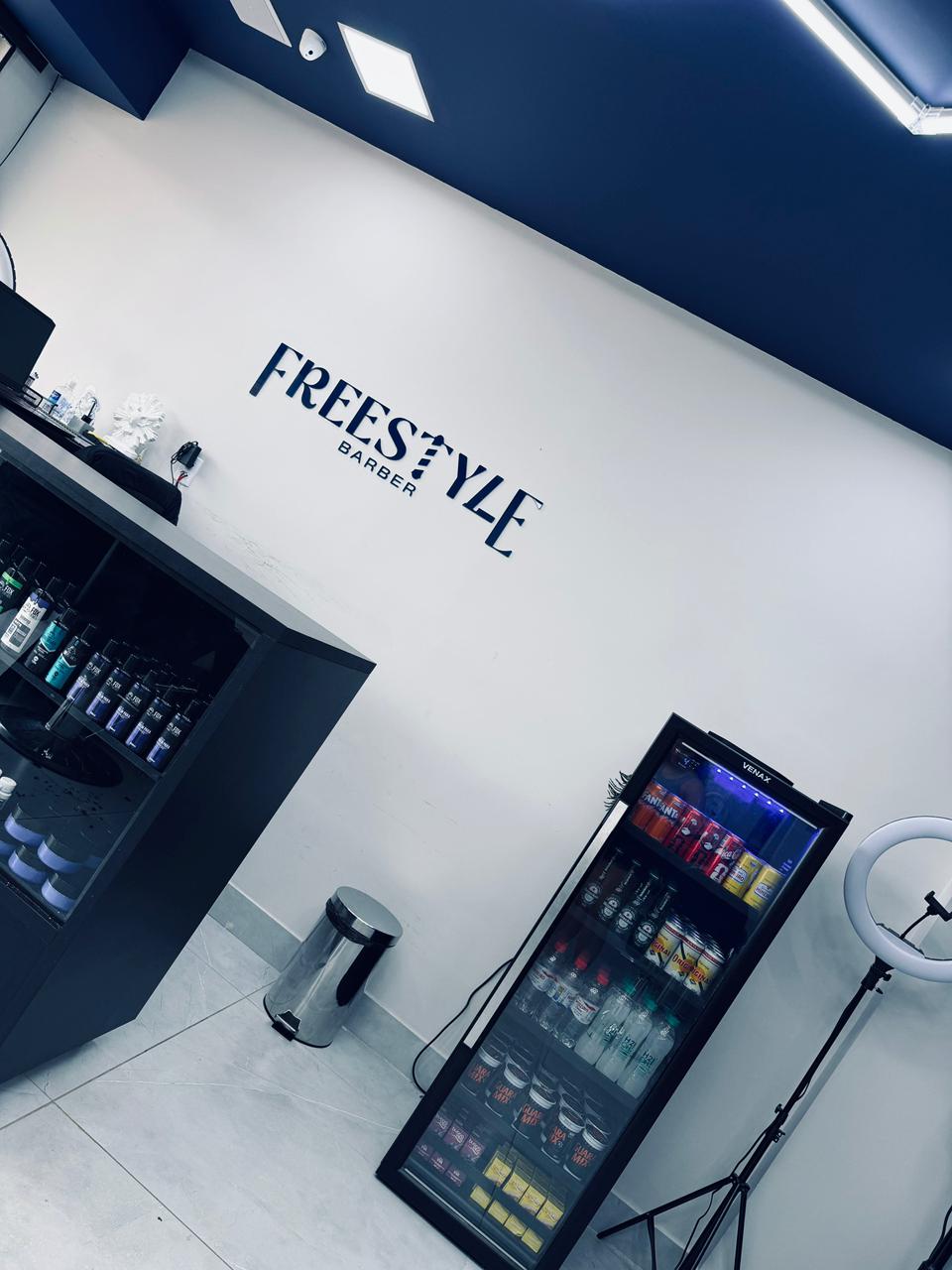Interior da Freestyle Barber com logo na parede
